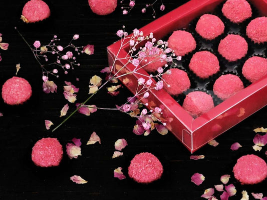 Himbeerpralinen in eleganter Geschenkbox, dekoriert mit getrockneten Blüten – edles Pralinenset zum Selbermachen oder Verschenken